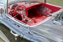 Madame Invest liebt schnelle Autos und den Wind in den Haaren bei einem sonnigen Tag. Das Bild zeigt eins der Lieblingsfahrzeuge. Eine Corvette.